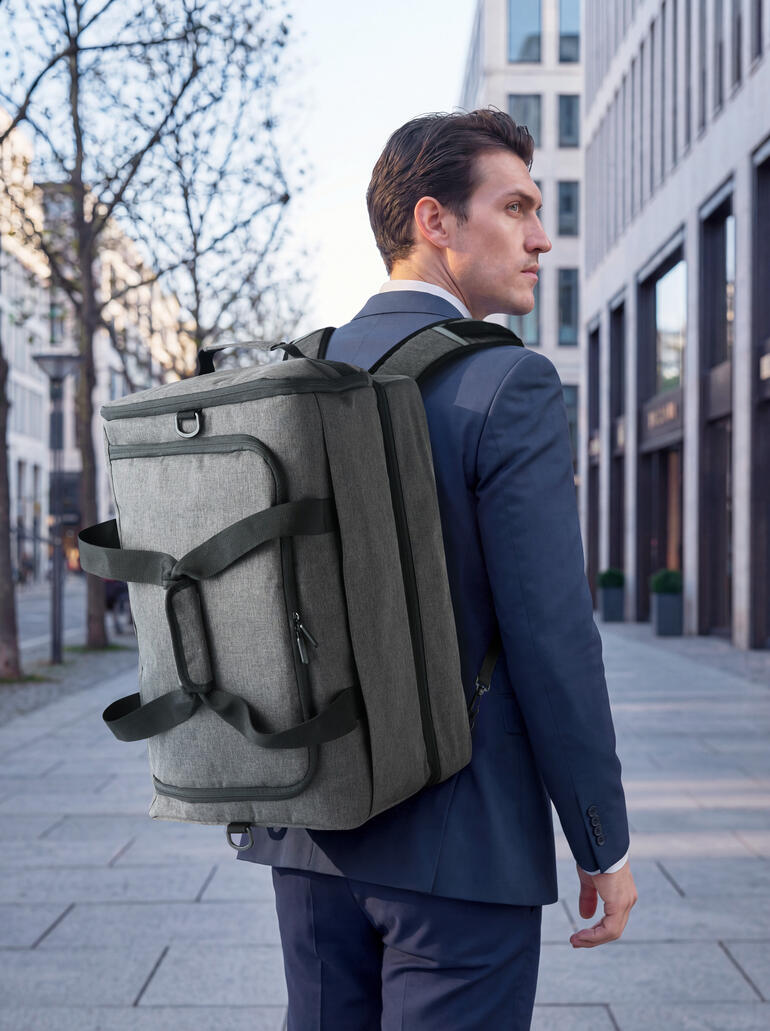 Mann trägt graue 2-in-1 Allroundtasche auf dem Rücken in der Stadt.