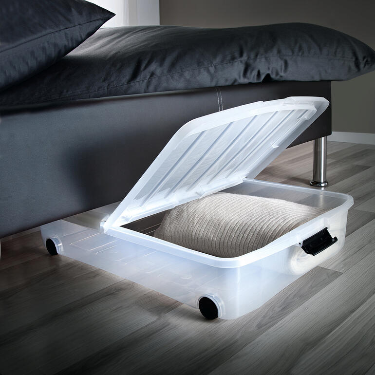 Unterbettbox mit Klappdeckel unter einem Bett.