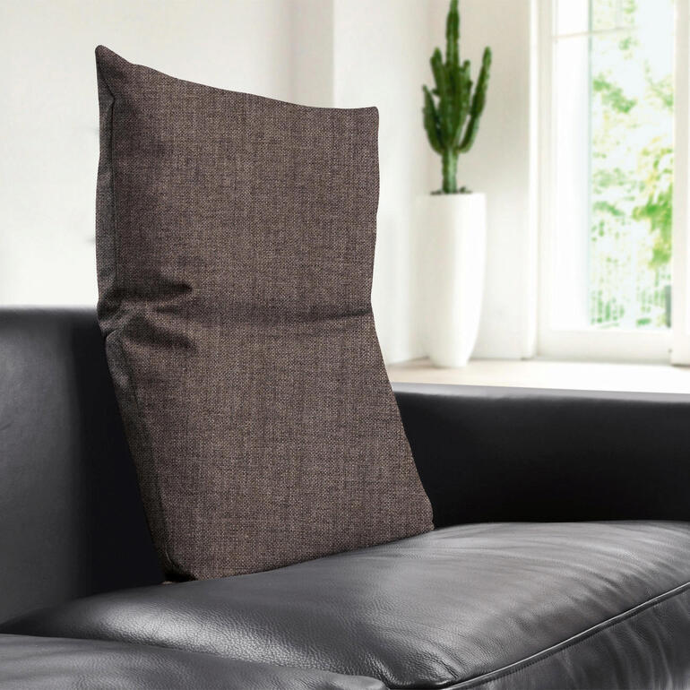 Braunes Rückenkissen auf einem schwarzen Sofa.