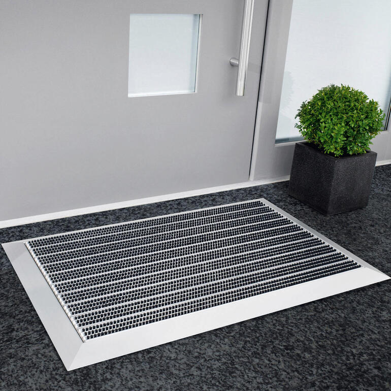 Alu-Empfangsmatte vor einer Eingangstür, innen aufgelegt.