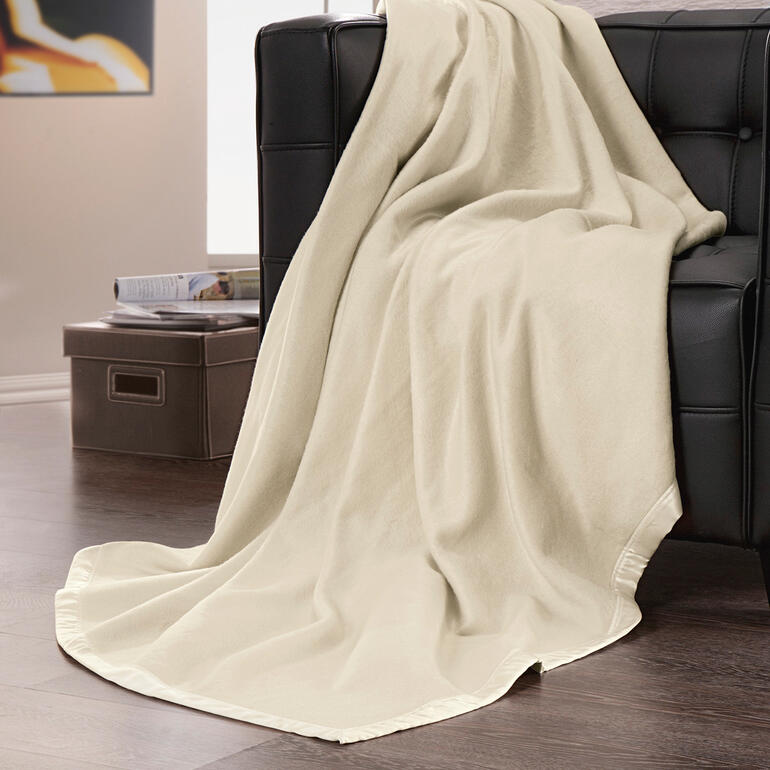 Seiden-Fleecedecke in sanften Beigetönen auf einem Sofa