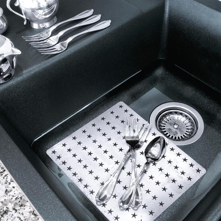 Reinigungsplatte auf einer Spüle mit Edelstahl-Töpfen.