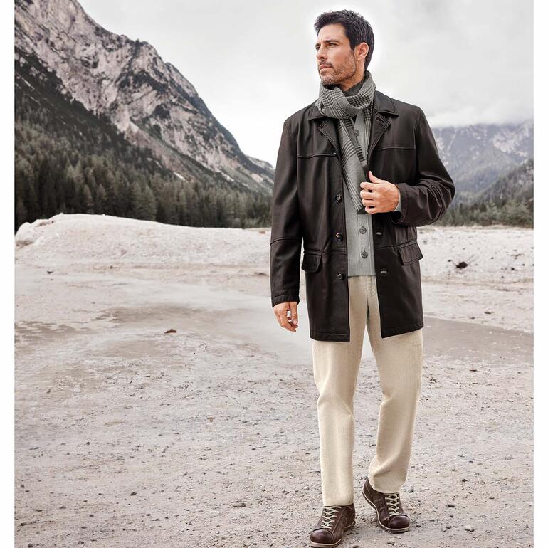 Mann in Elchlederjacke in bergiger Landschaft