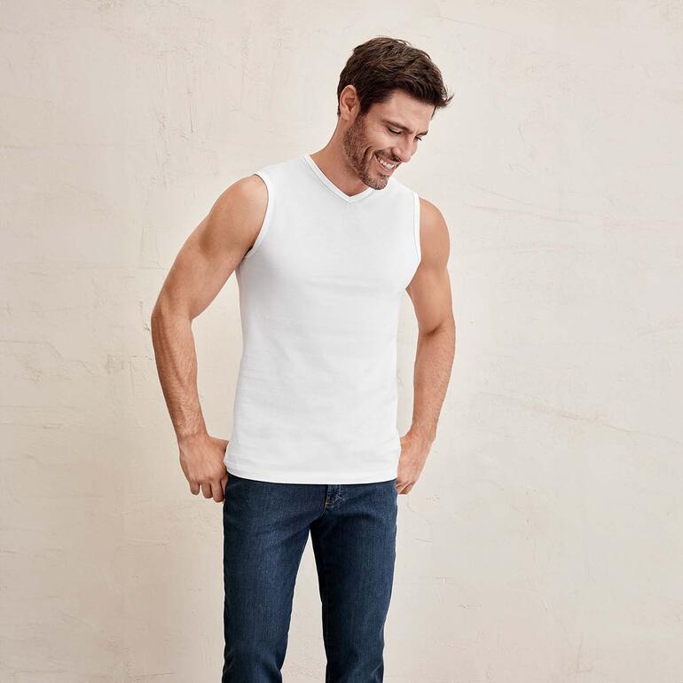 Mann in ärmellosem Shirt, lächelt und schaut nach unten