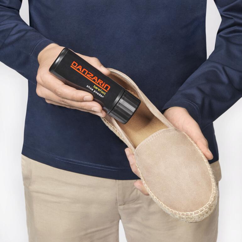 Danzarin Schuhpuder in Hand eines Mannes, bereit zur Anwendung auf einem Schuh.