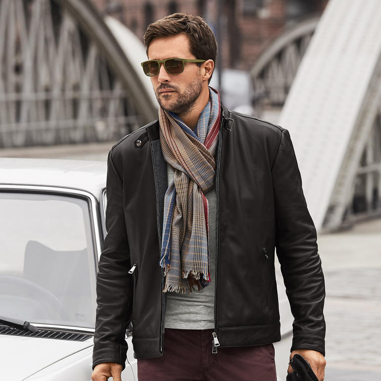 Mann in schwarzem Arma Hirschleder-Blouson mit Schal.