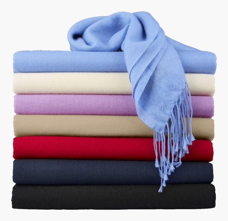 Bunt gestapelte Pashmina-Schals mit blauem Schal obendrauf.