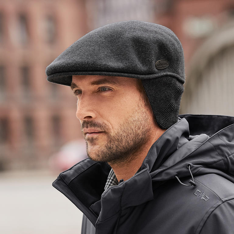 Seitenansicht eines Mannes in Kangol-Schiebermütze mit Ohrenwärmern.