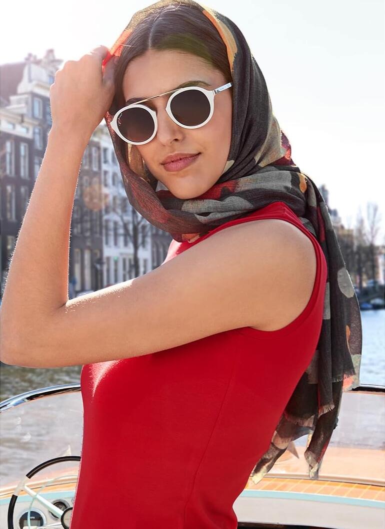 Nahaufnahme einer Frau mit Kopfschal im roten Kleid.