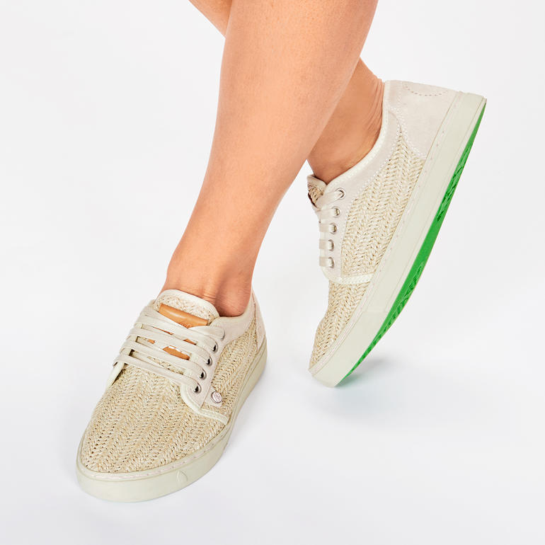 Beige Flecht-Sneaker mit grüner Sohle und Schnürung.
