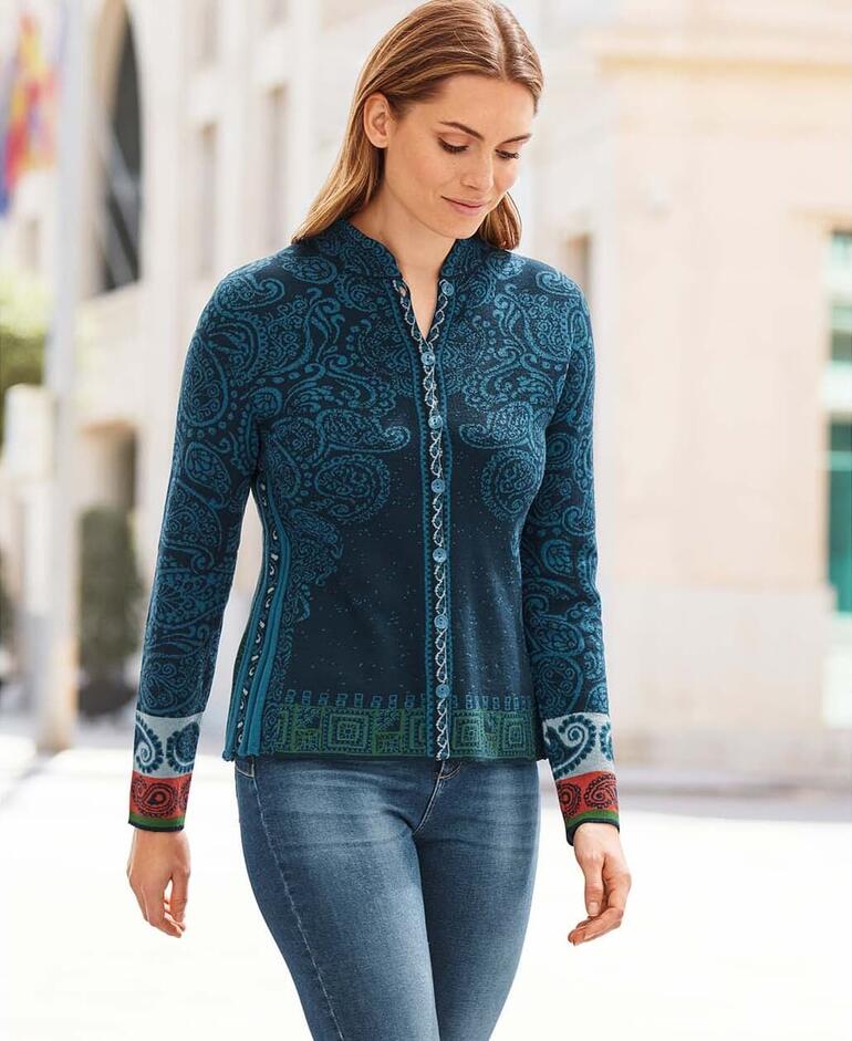 Frau trägt eine blaue Jacquardjacke mit Paisleymuster im Freien auf einer europäischen Straße.