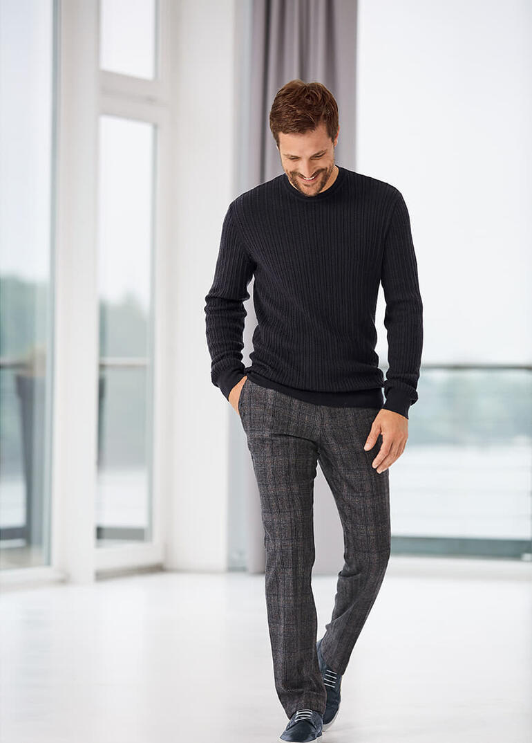 Tom Ripley Zopf-Pullover, schwarz, model lächelt beim Gehen.