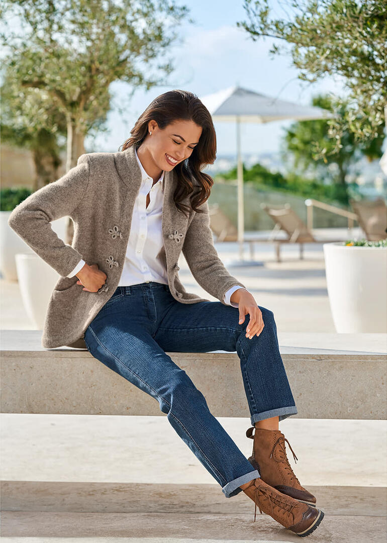 Cognacfarbene Werner Budapester-Boots, seitlich auf einem Stein sitzend.