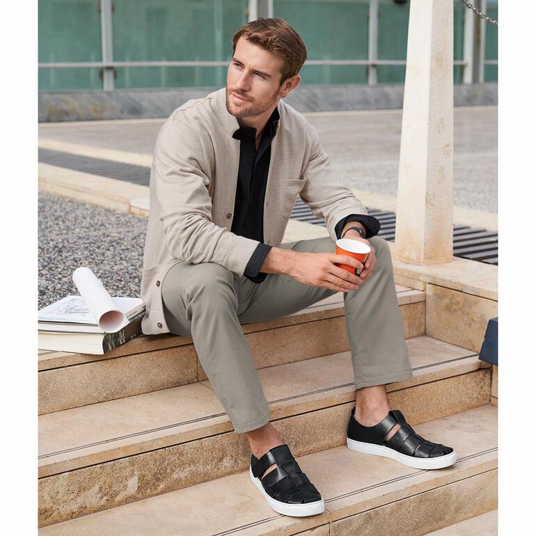 Mann in beiger Pima-Cotton-Cardigan, entspannt sitzend.