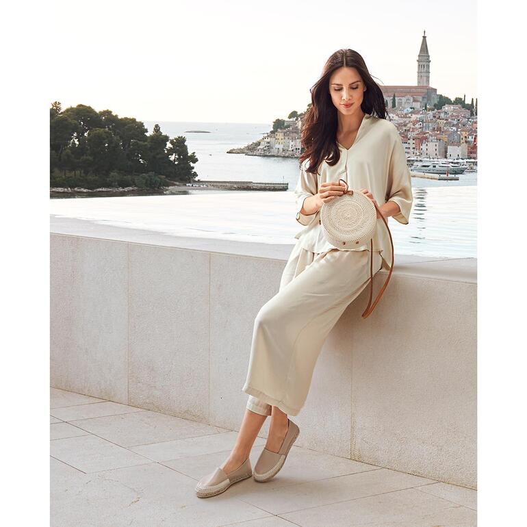 Blouse et Pantalon Palazzo raccourcit, Crème Beige Tunika-Bluse mit V-Ausschnitt und langen Ärmeln auf weißem Hintergrund.