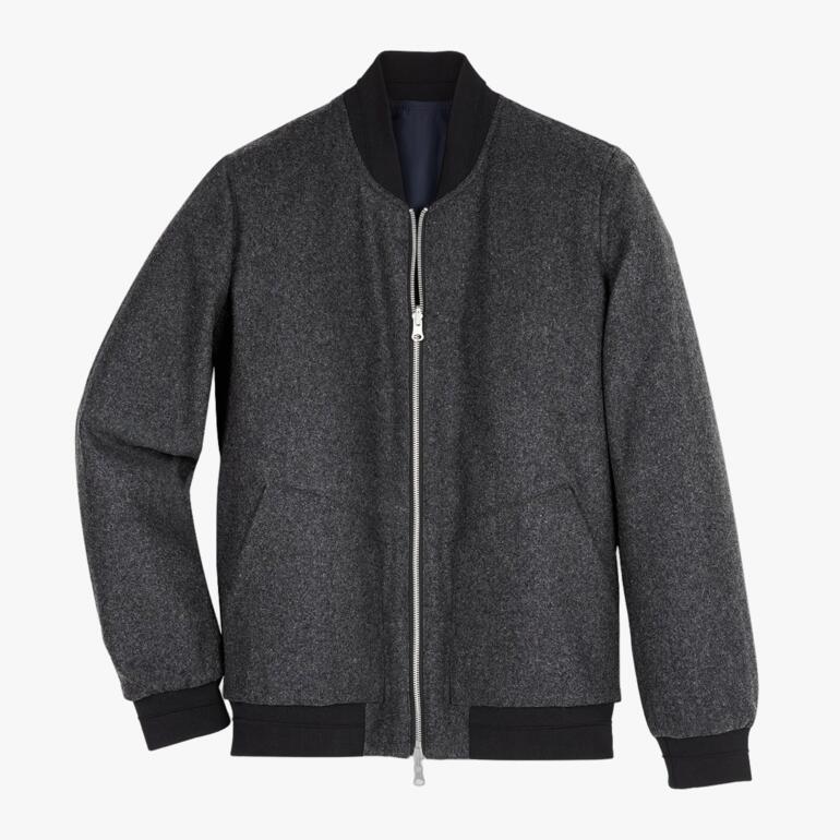 Wende-Blouson in grau, liegend auf einem Tisch.