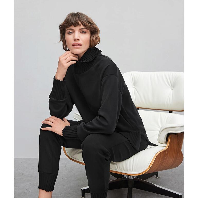 Schwarzes Sweatshirt mit hohem Kragen auf einem weißen Hintergrund.