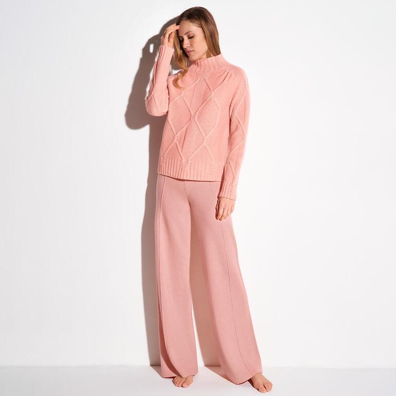 Vorderansicht eines pinkfarbener Strickpullovers mit Zopfmuster.