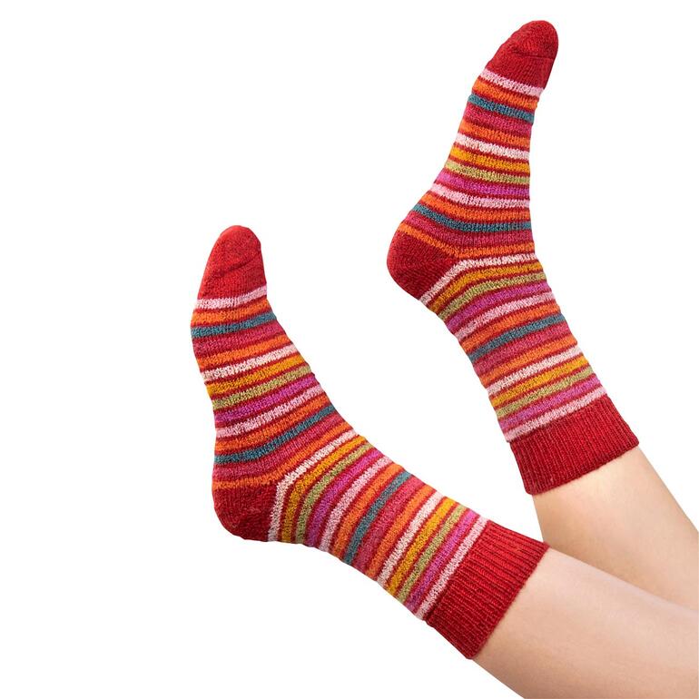 Paar rote Regenbogen-Ringelsocken an den Füßen.