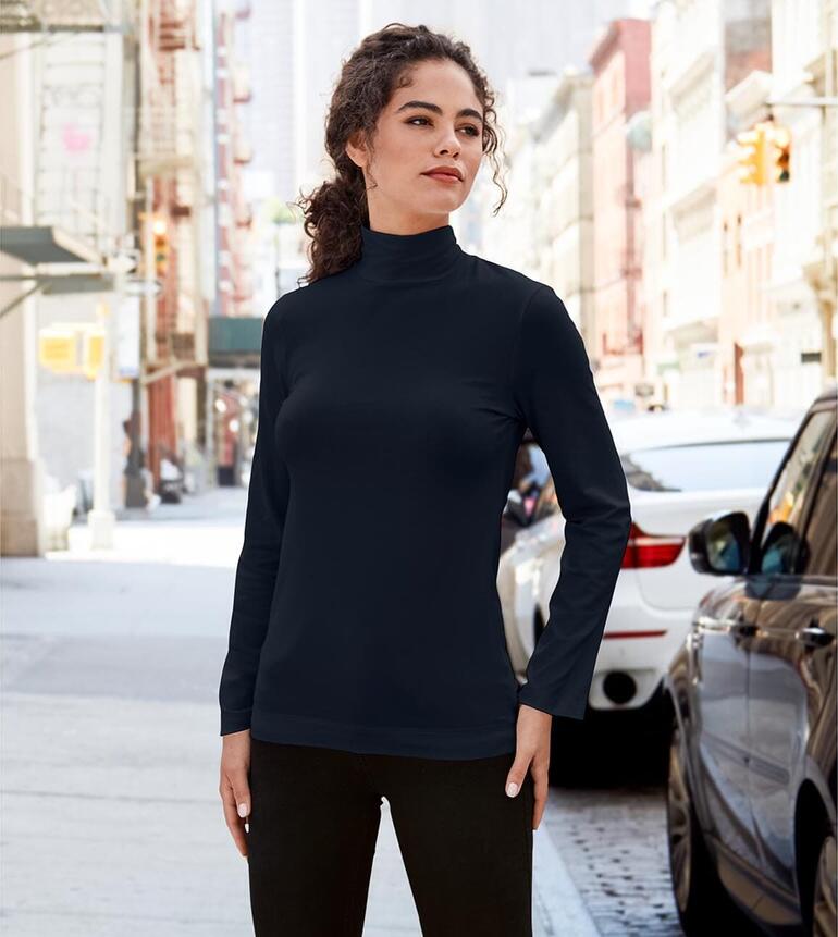 Frau in schwarzem Baumwoll/Kaschmir-Highneck-Shirt auf einer Straße.