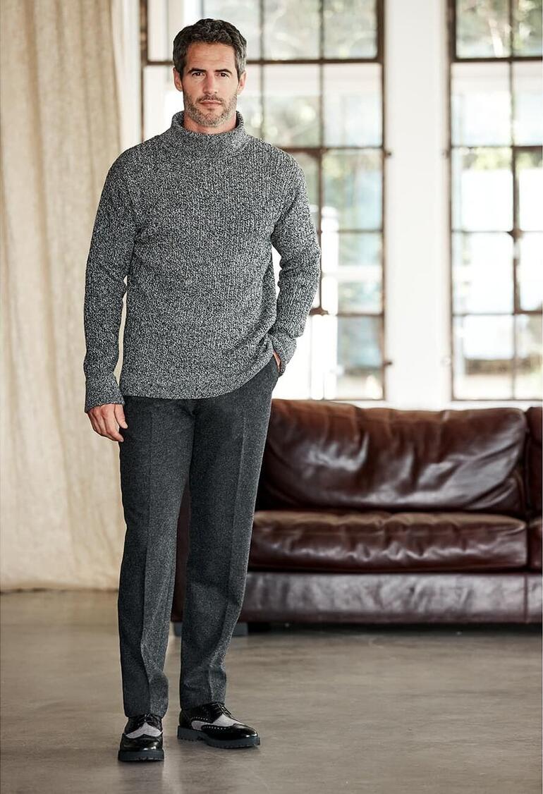 Tom Crean Antarktis-Pullover Mann trägt designen Antarktis-Pullover in grau vor gemütlichem Hintergrung