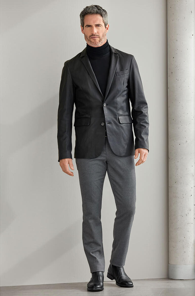 OCONI Lammnappa-Blazer Mann in schwarzem OCONI Lammnappa-Blazer auf neutralem Hintergrund