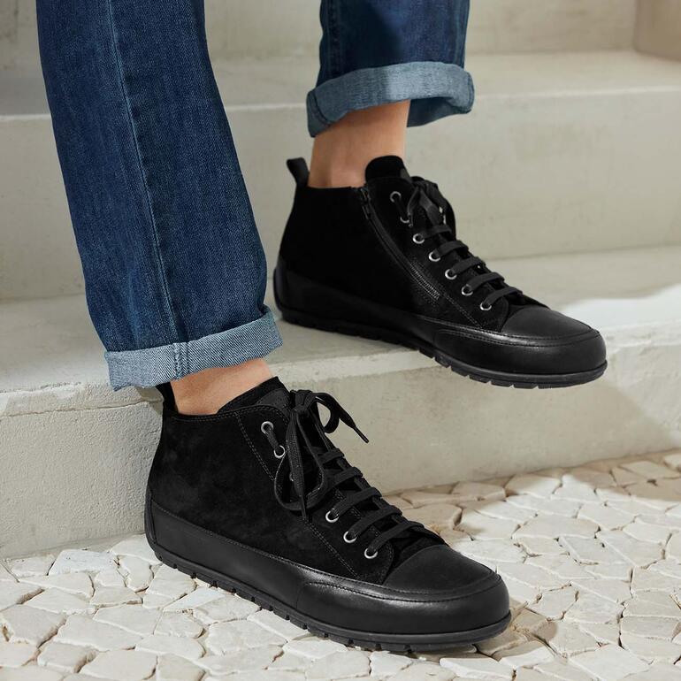 Schwarze Mid Cut Sneaker aus Wildleder mit Schnürung, getragen mit Jeans.
