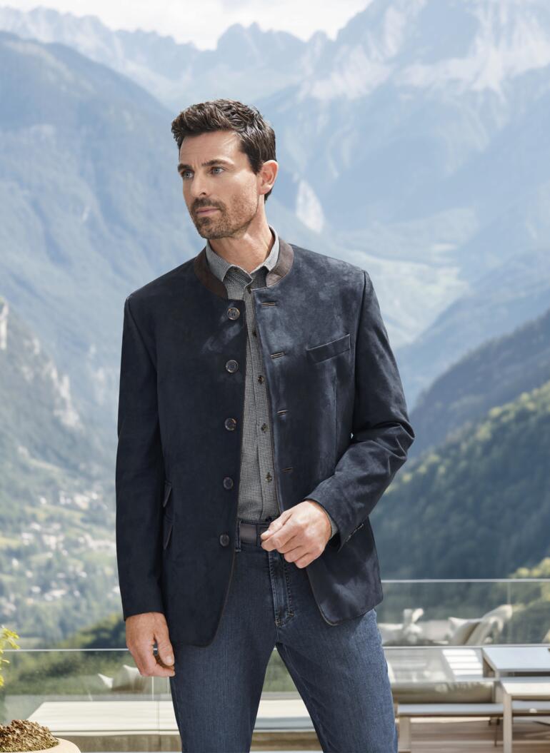Kaschmir-Flanellhemd Vichykaro Mann in dunkelblauem Velours-Janker vor Alpenlandschaft.