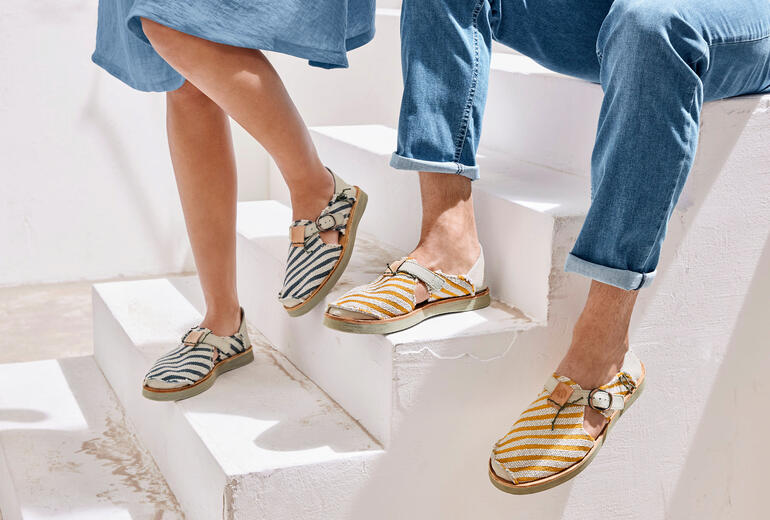 Blau/Creme und Gelb/Creme Zwei Füße in Satorisan Canvas-Sneaker-Sandalen auf einer Treppe