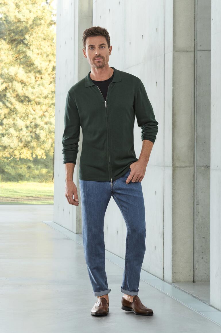 OCONI Tassel-Loafer Mann in grüner Jacke und Jeansmodel mit braunen Tassel-Loafern.