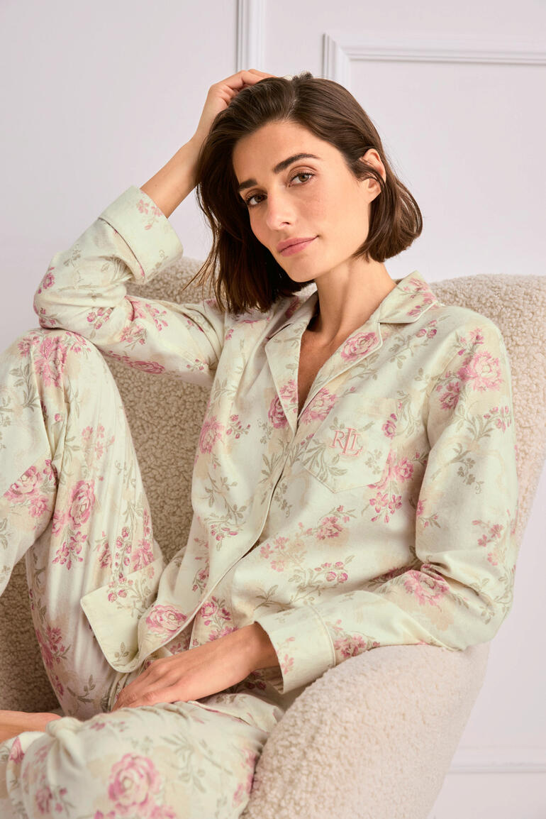 Frau in floralem Ralph Lauren Pyjama, sitzend und nachdenklich.
