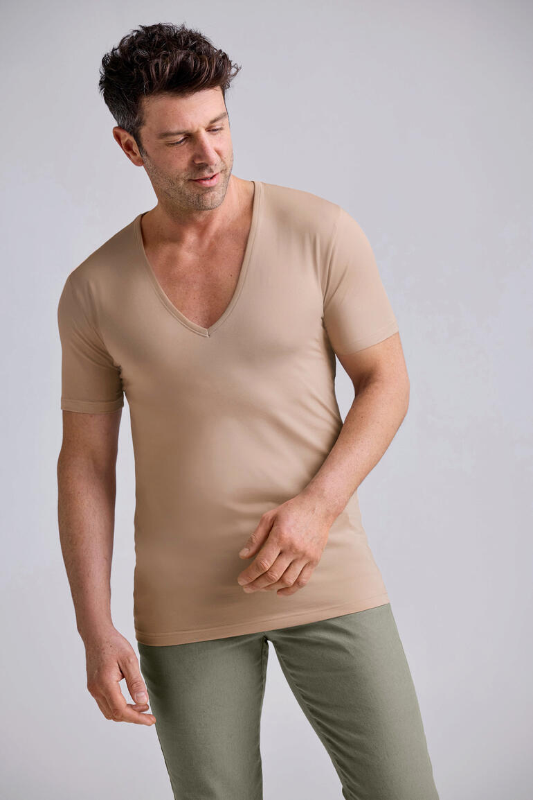Beige Mann trägt beiges Untershirt mit V-Ausschnitt.