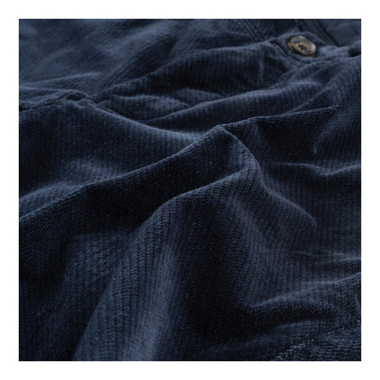 Detailansicht einer blauen Samthose mit feiner Struktur.