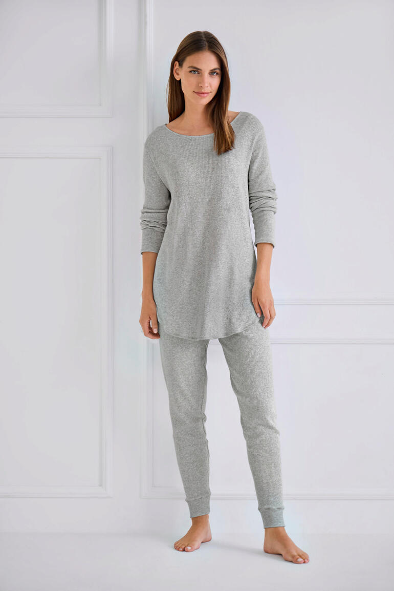 Frau in grauem Pyjama mit Oberteil und Hose