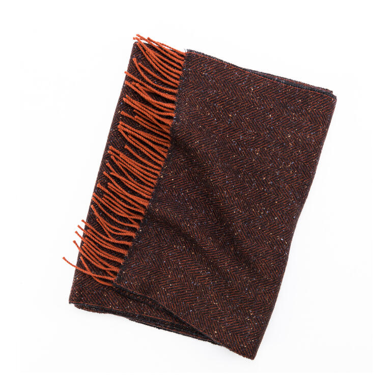 Tweed-Schal in dunkelorange und braun, auf einem Tisch gelegt.