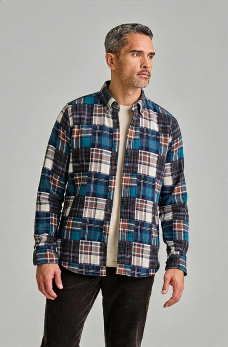 Mann steht seitlich, trägt ein kariertes Flanellhemd in Blau mit einem T-Shirt.
