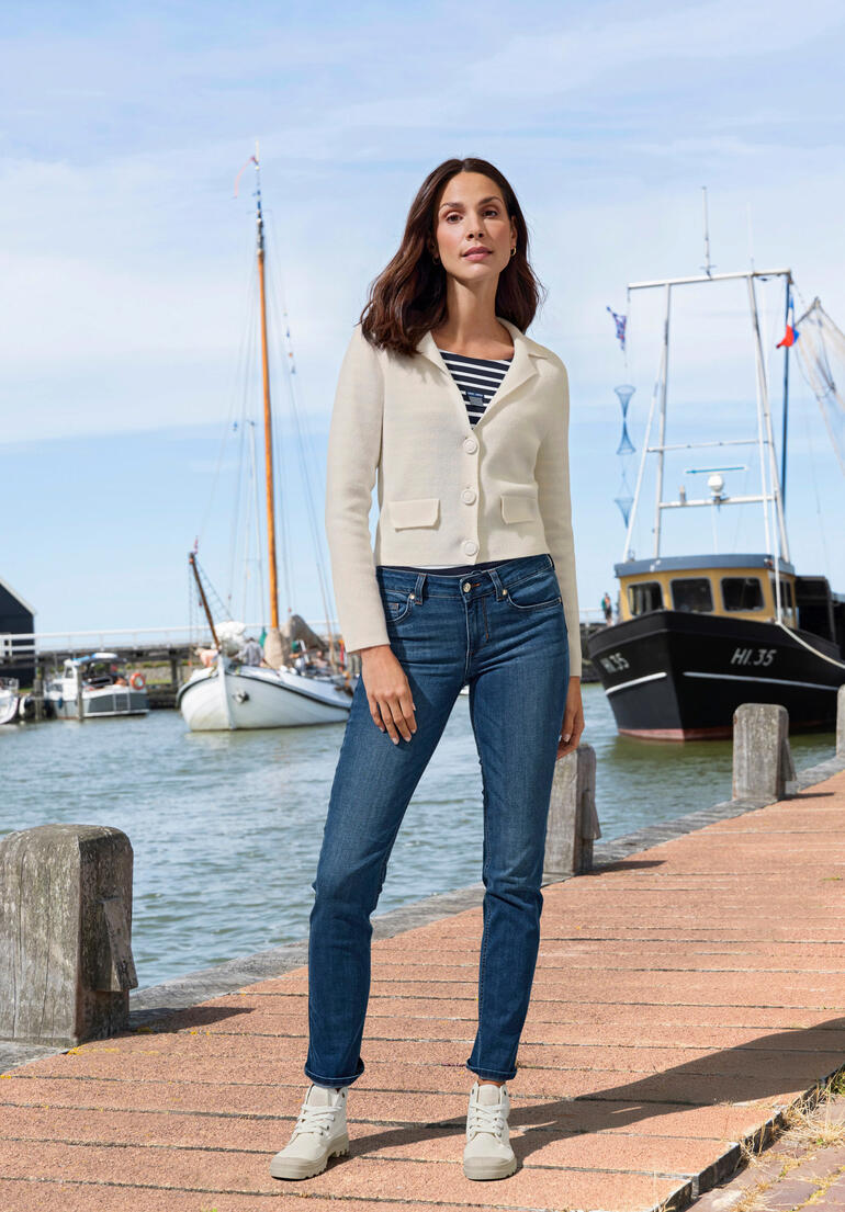 Weiss Frau in einem weißen Kaschmir-Blazer am Hafen