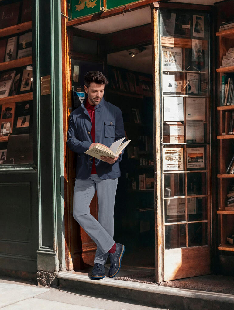 Steinbock® Ultraleicht-Cityjacke Mann in Steinbock® Ultraleicht-Cityjacke liest vor einer Buchhandlung.