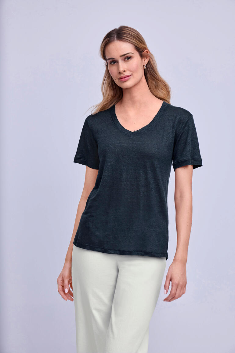 Frau trägt schwarzes Edel-Leinen-Shirt mit V-Ausschnitt.