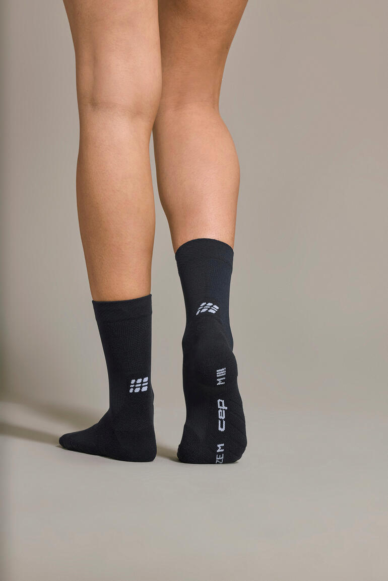 Schwarze Core Sportsocke, von hinten an einem Fuß getragen.