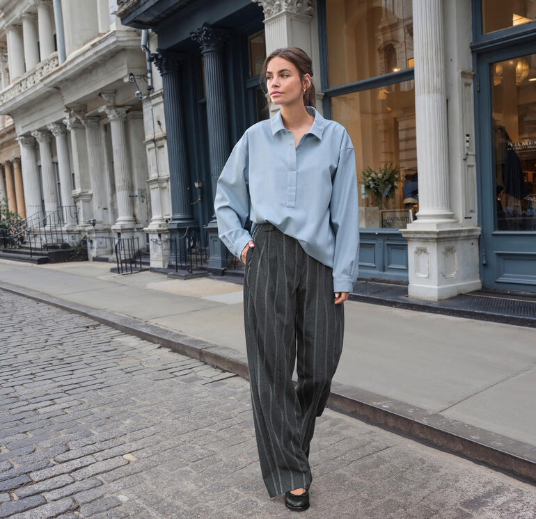 Frau trägt blaue Winter-Jeans-Tunikabluse beim Gehen