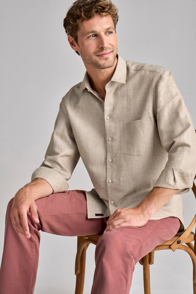 Hanf-Merino-Hemd in Sandfarbe, Model sitzt auf einem Stuhl.