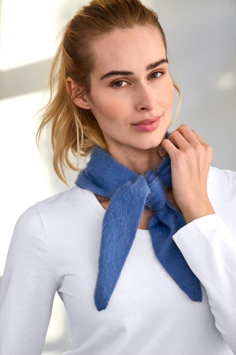 Blaues Kaschmir-Halstuch, mit einem Knoten um den Hals einer Frau gebunden.