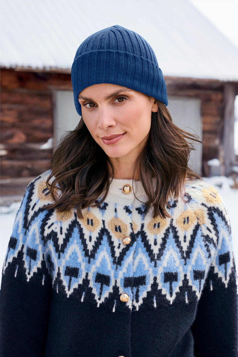 Blau Frau trägt blaue Kaschmir-Fischermütze und gemusterte Jacke.