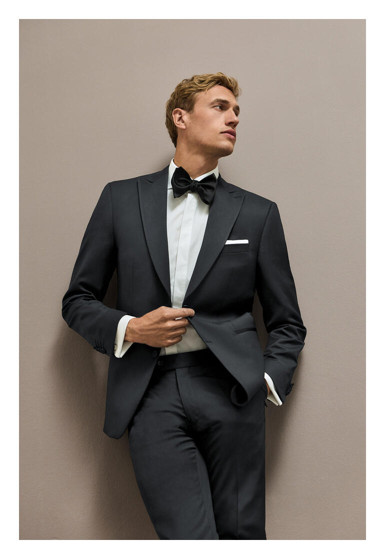 Mann in schwarzem Smoking-Sakko mit Fliege