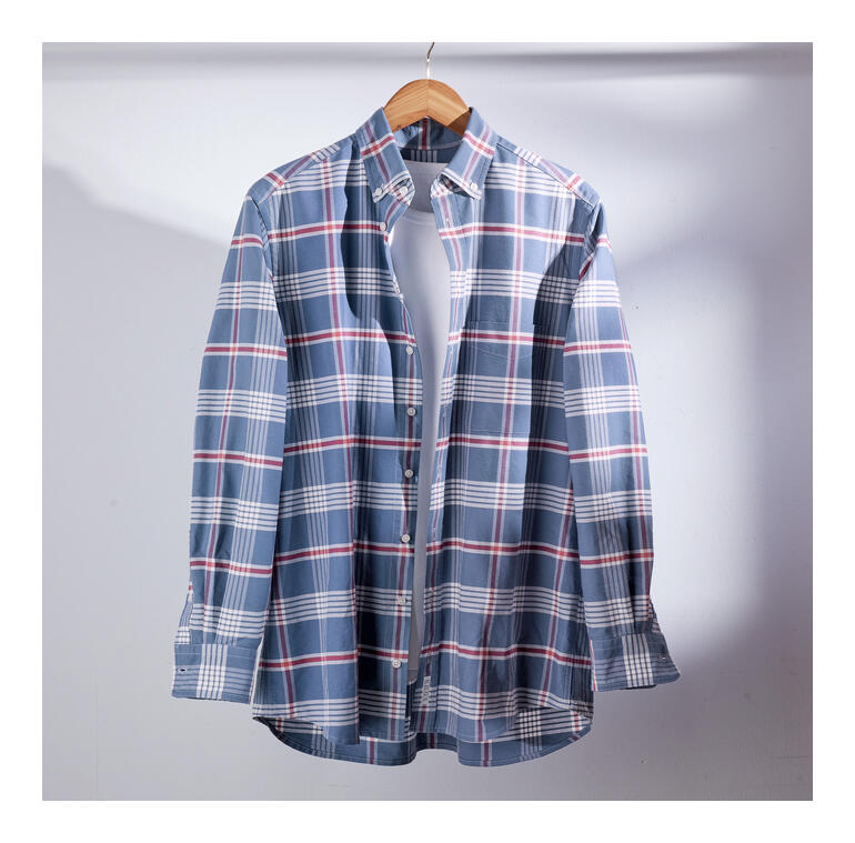 Kariertes Hemd in Blautönen, lässig hingehängt auf einem Holzbügel