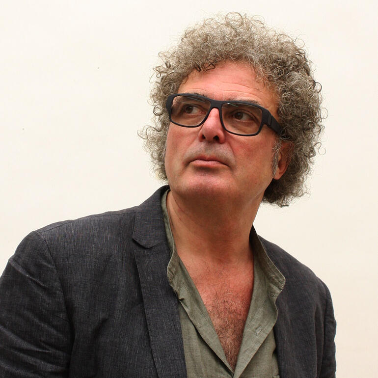 Jacinto Moros Mann mit lockigem Haar trägt eine Brille und schaut nachdenklich.