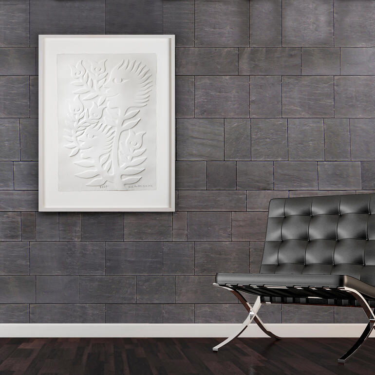 Kunstwerk mit Reliefdarstellung in einem modern eingerichteten Raum.