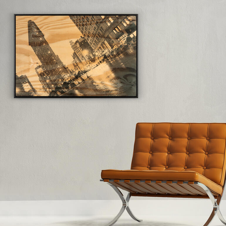 Rahmen mit dem Bild des Flatiron-Gebäudes an einer Wand über einem modernen Sessel.