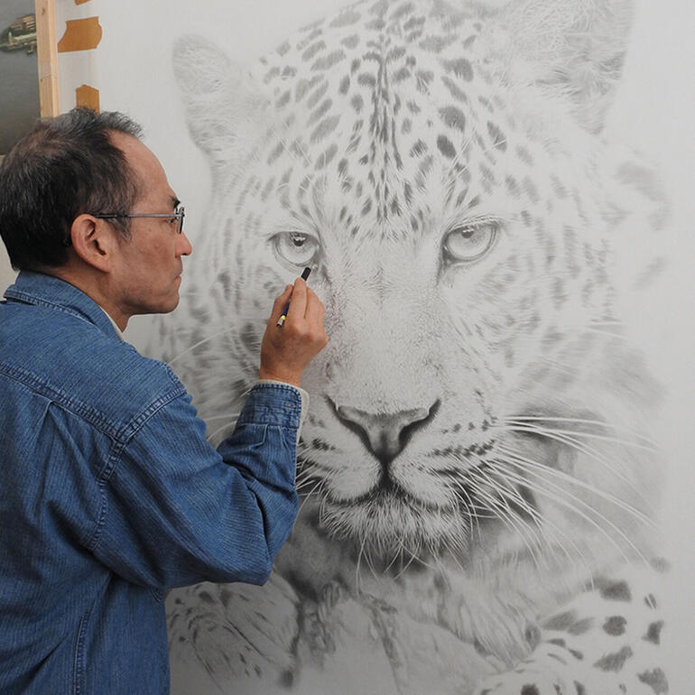 Künstler zeichnet einen Leoparden an einer Wand.